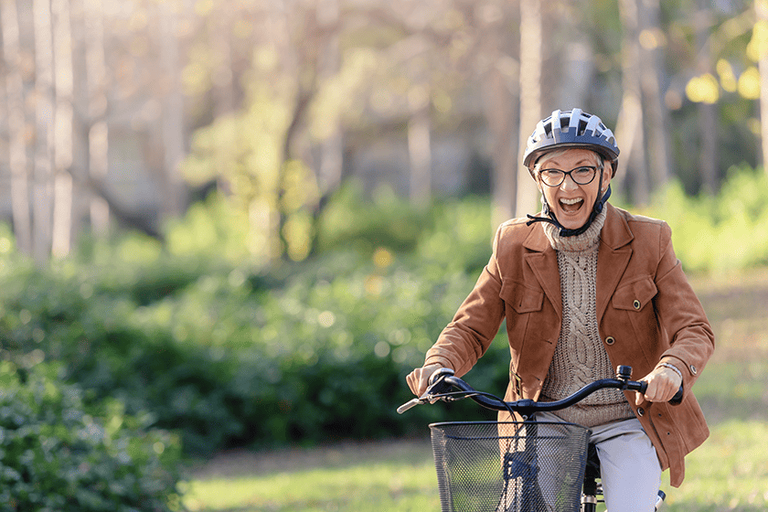 cheerful elderly woman riding bicycle