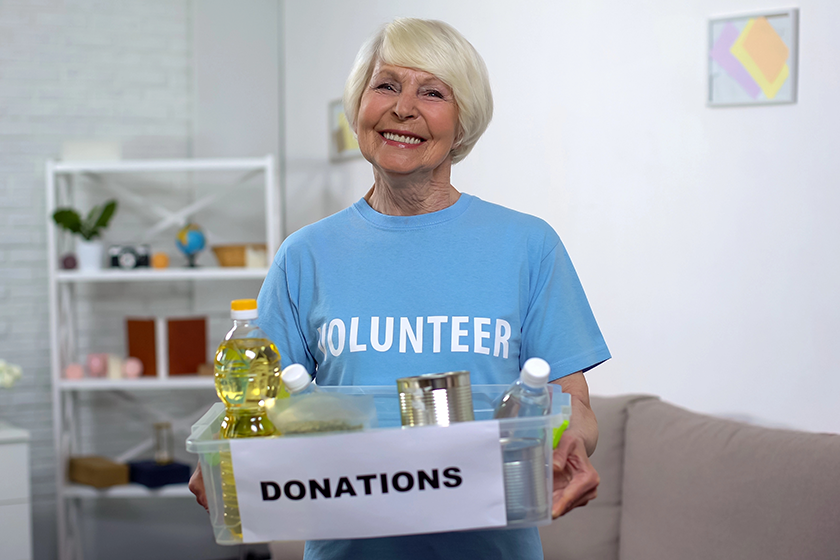 Happy female volunteer holding donation box