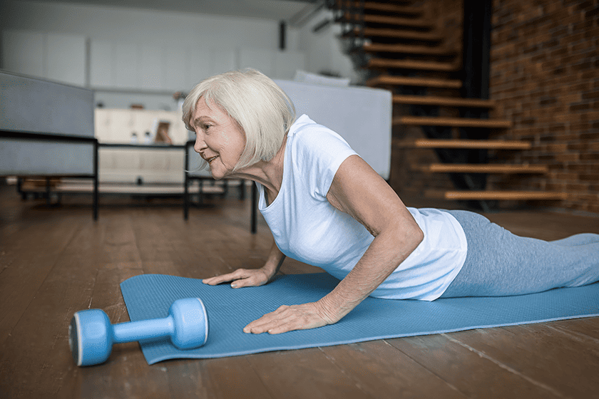 senior woman in a white tshirt doing plank